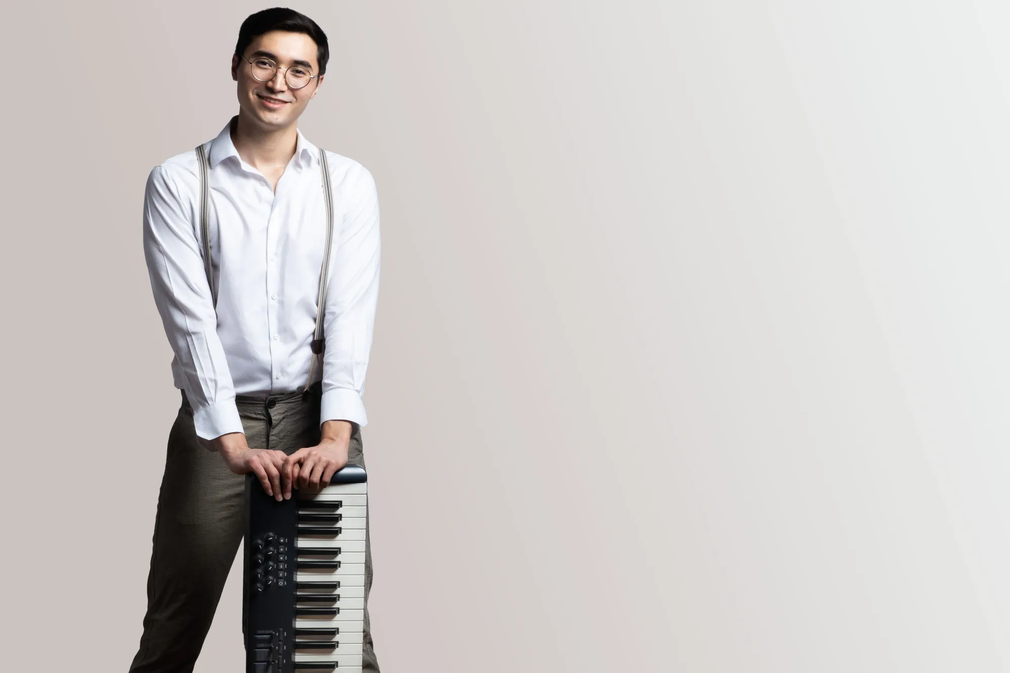 A Composition student with his electronic keyboard smiles into camera